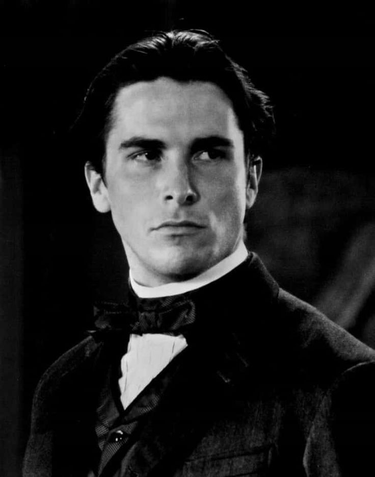 a man in a tuxedo and bow tie looking at the camera with an intense look on his face