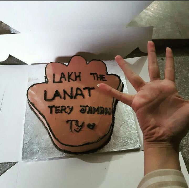 a cake with the words lah the lanat on it is being held up by someone's hand