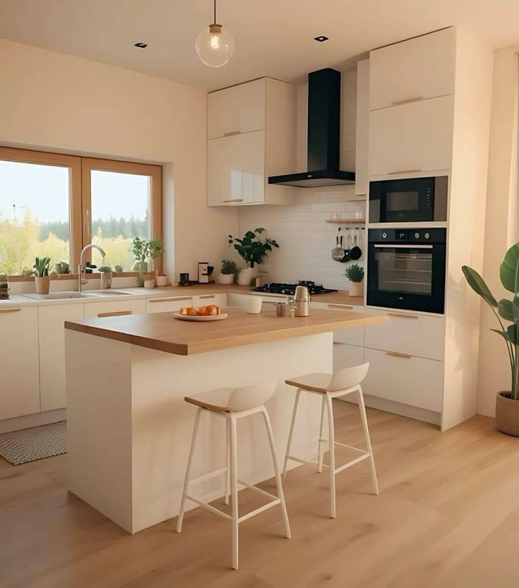 a kitchen with two stools in front of the counter and an island next to it