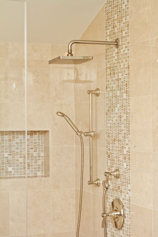 a shower head and hand held shower faucet in a tiled bathroom with beige tiles