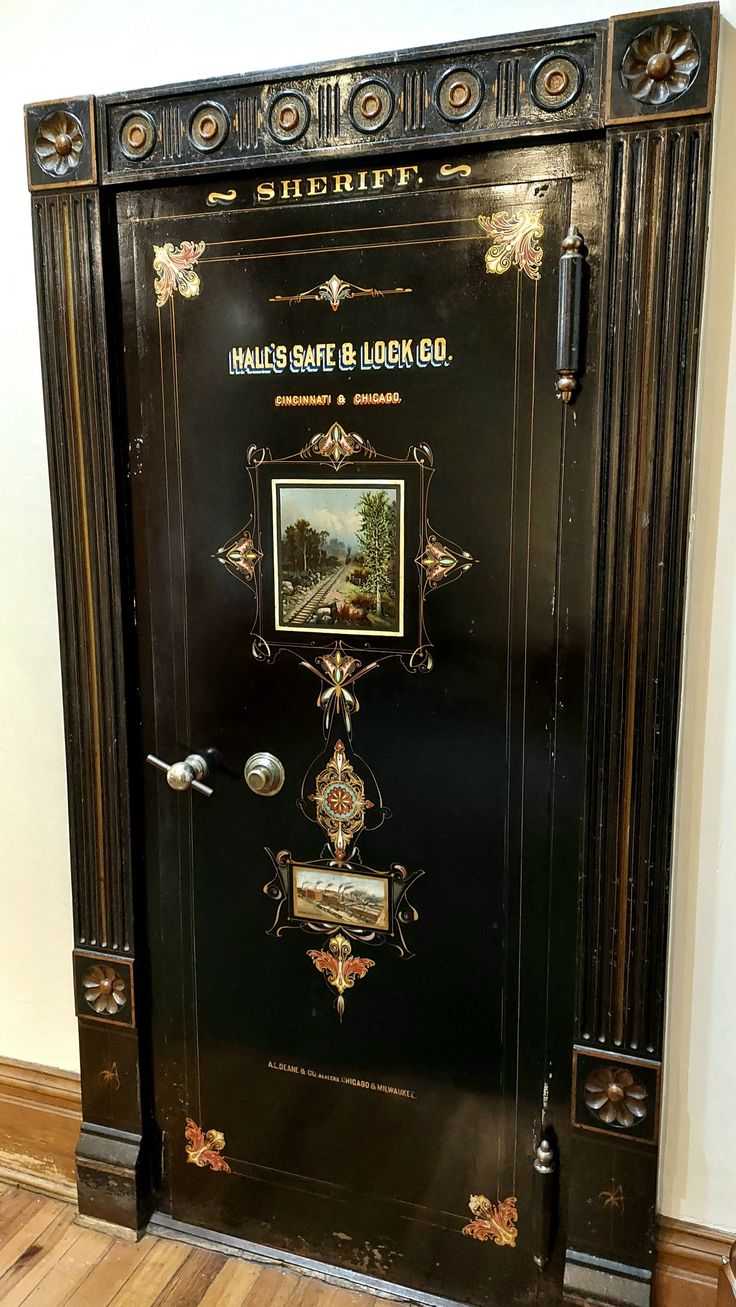 an old fashioned black safe with pictures on the front and side panels is shown in this photo