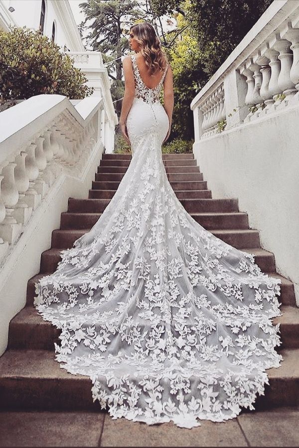 a woman in a wedding dress walking down some stairs