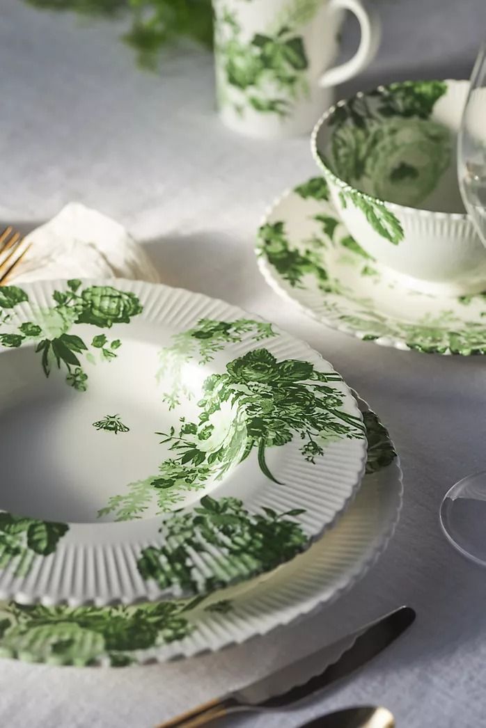 a table set with plates, cups and utensils