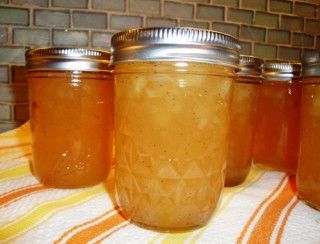 four jars filled with liquid sitting on top of a table