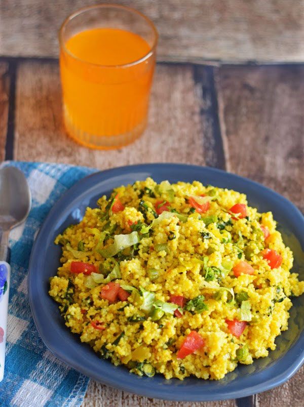 a blue plate topped with rice and veggies next to a glass of orange juice