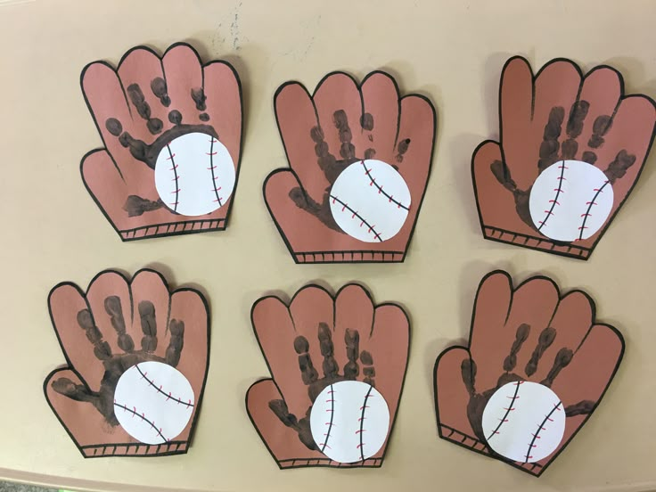 four handprinted baseball mitts are shown on the wall in this classroom setting