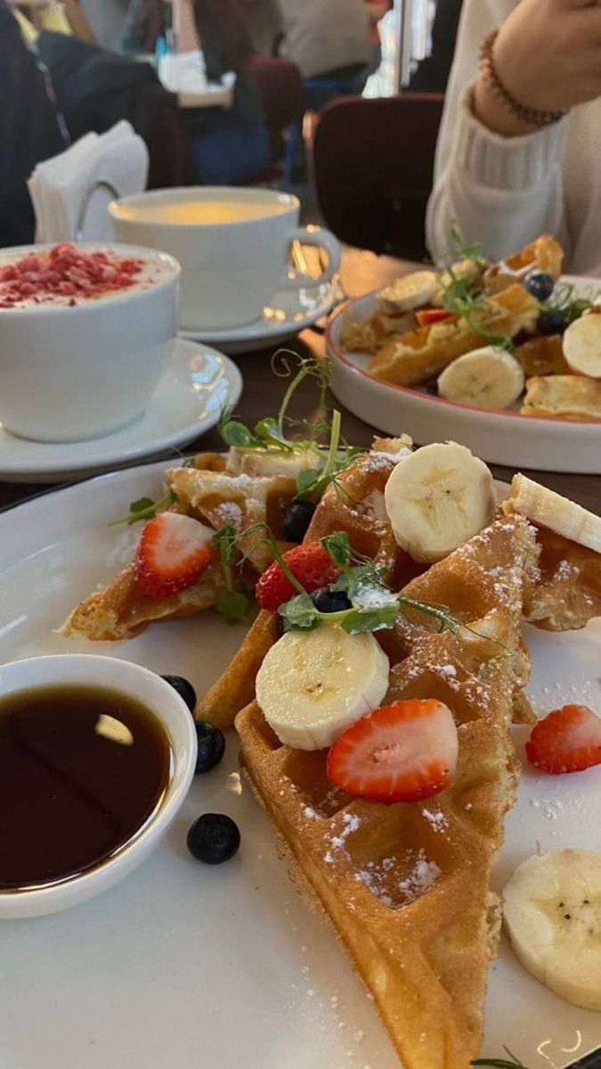 a plate topped with waffles covered in bananas and strawberries