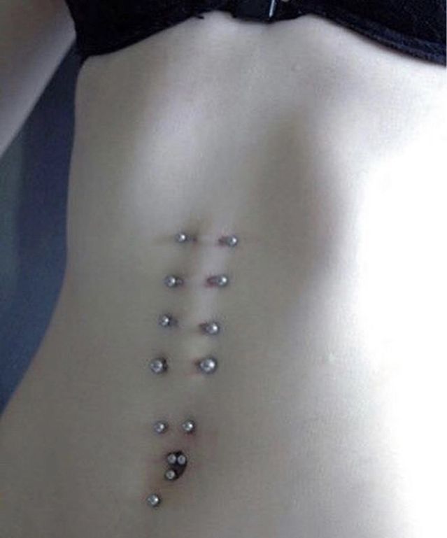 a woman's stomach with small beads on the side and an arrow in the middle