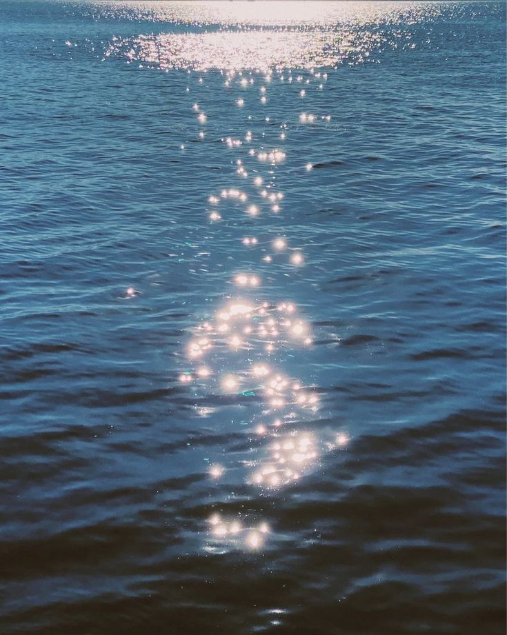 the sun is shining down on the water and it looks like something floating in the air