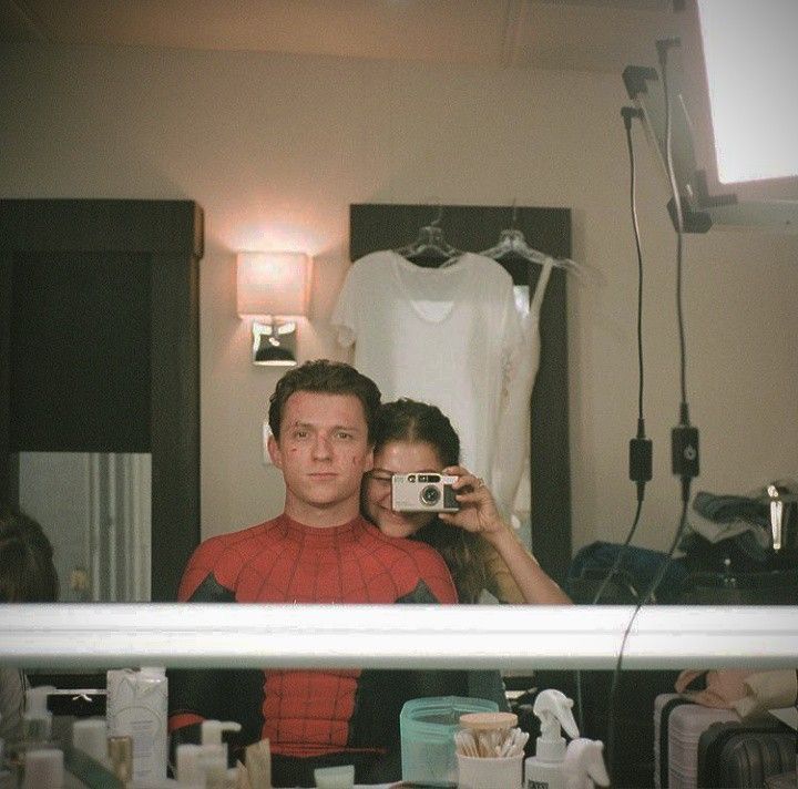 a man and woman taking a selfie in front of a mirror