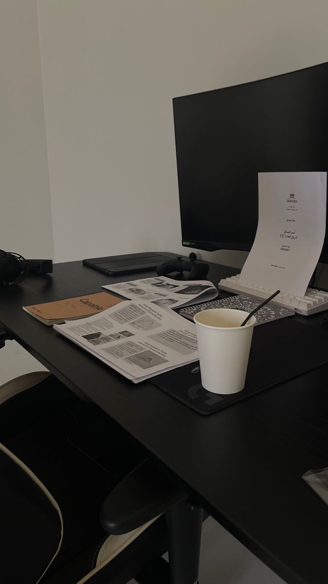 a cup of coffee sitting on top of a desk