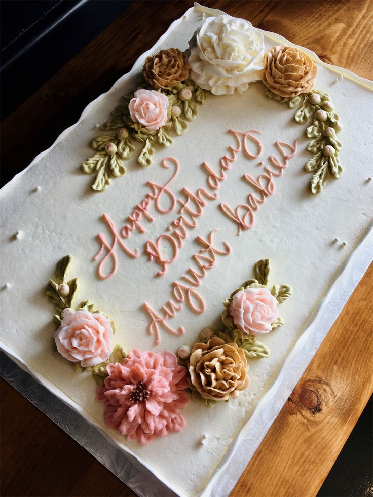 a birthday cake decorated with flowers on a table