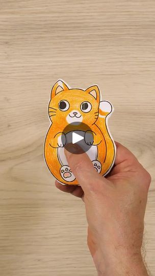 a hand holding a sticker with an image of a cat in the middle of it