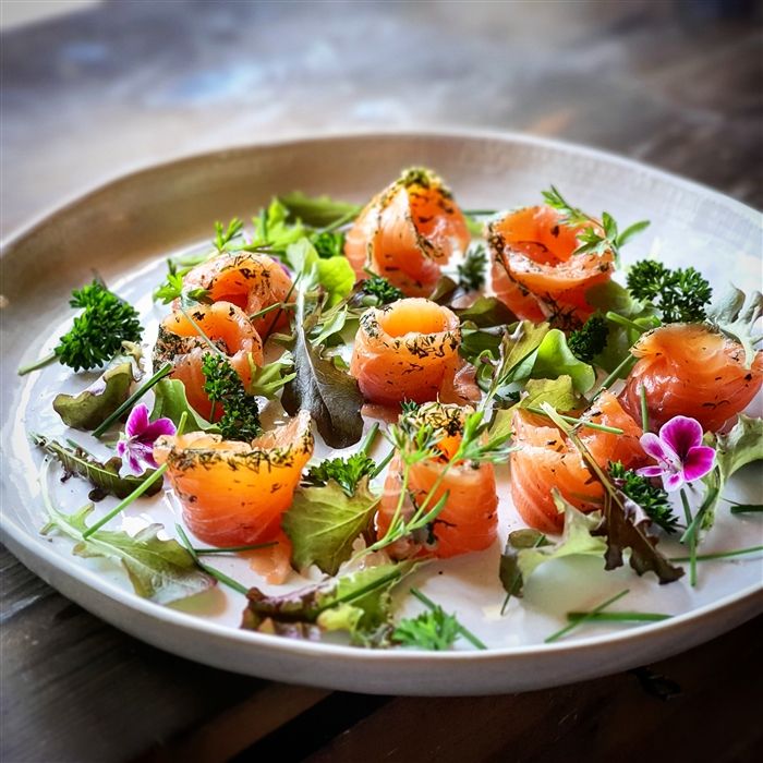 a white plate topped with lots of food on top of a wooden table