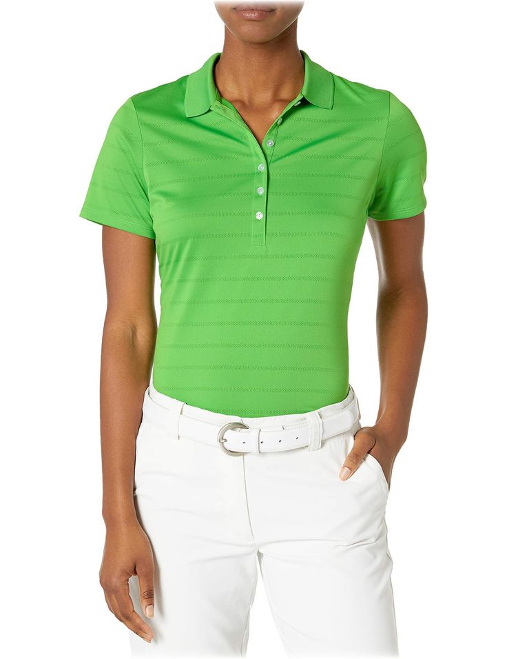 a woman wearing a green shirt and white pants