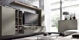 a modern living room with a large tv on the wall and bookshelves in front of it