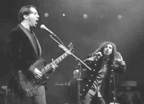 two people on stage with guitars and microphones