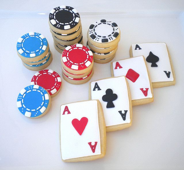 cookies decorated with playing cards and chips are sitting on a table next to poker chips