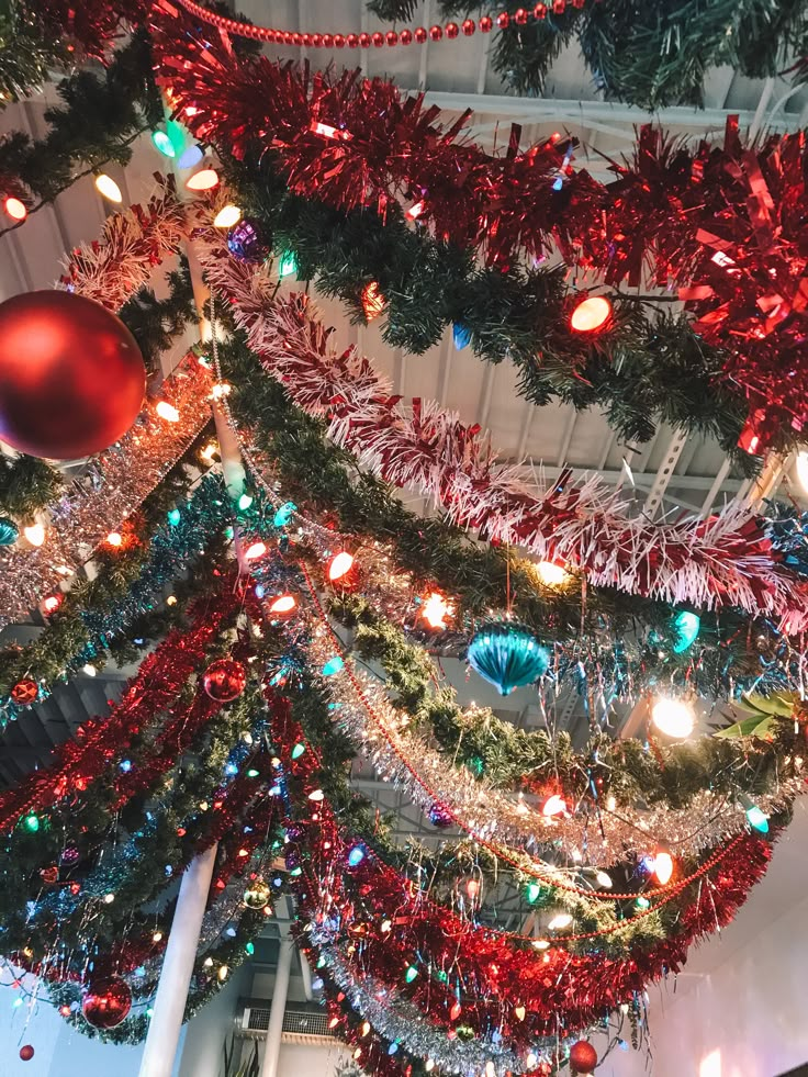 the christmas tree is decorated with red, green and blue ornaments on it's branches