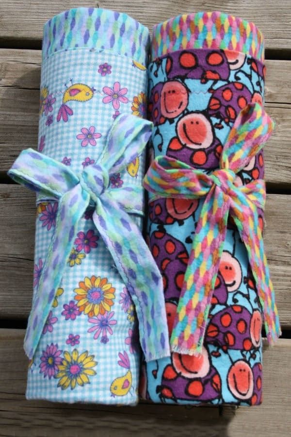 three rolls of fabric wrapped in different patterns and colors with a ribbon tied around them