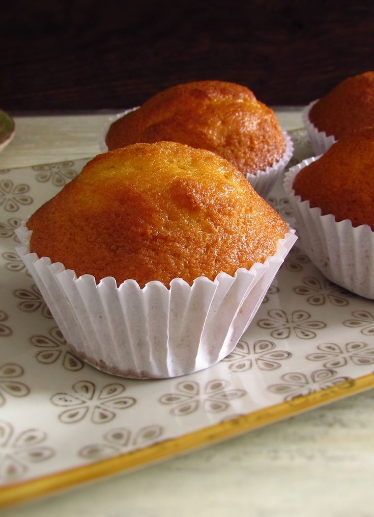 three muffins sitting on top of a white and yellow tray next to a spoon