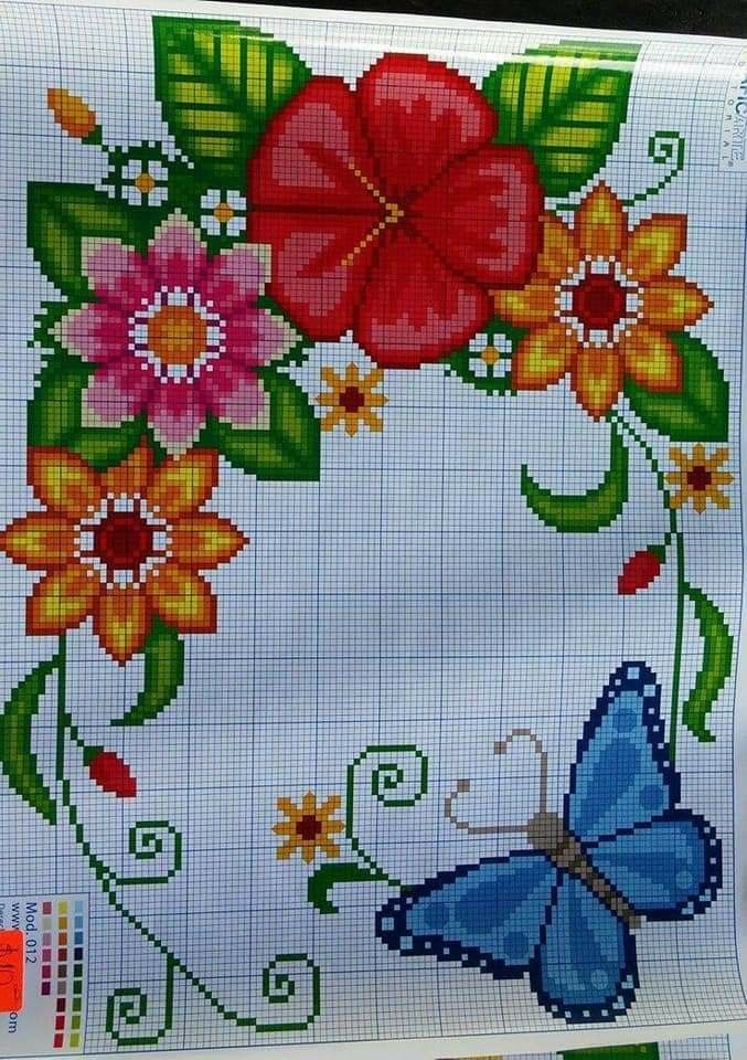 a cross stitch pattern with flowers and a blue butterfly on it's back side