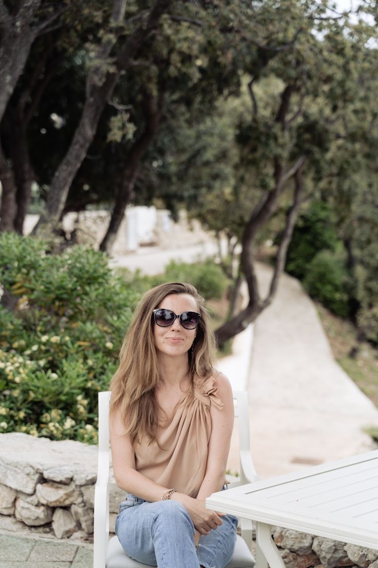 a woman sitting at a table with sunglasses on