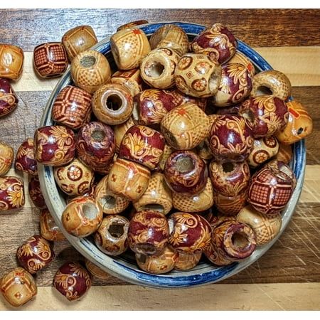 a bowl filled with lots of brown and white ceramic beads on top of a wooden table