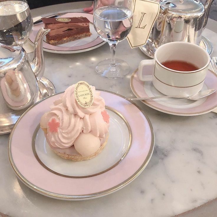 a table topped with plates and cups filled with desserts