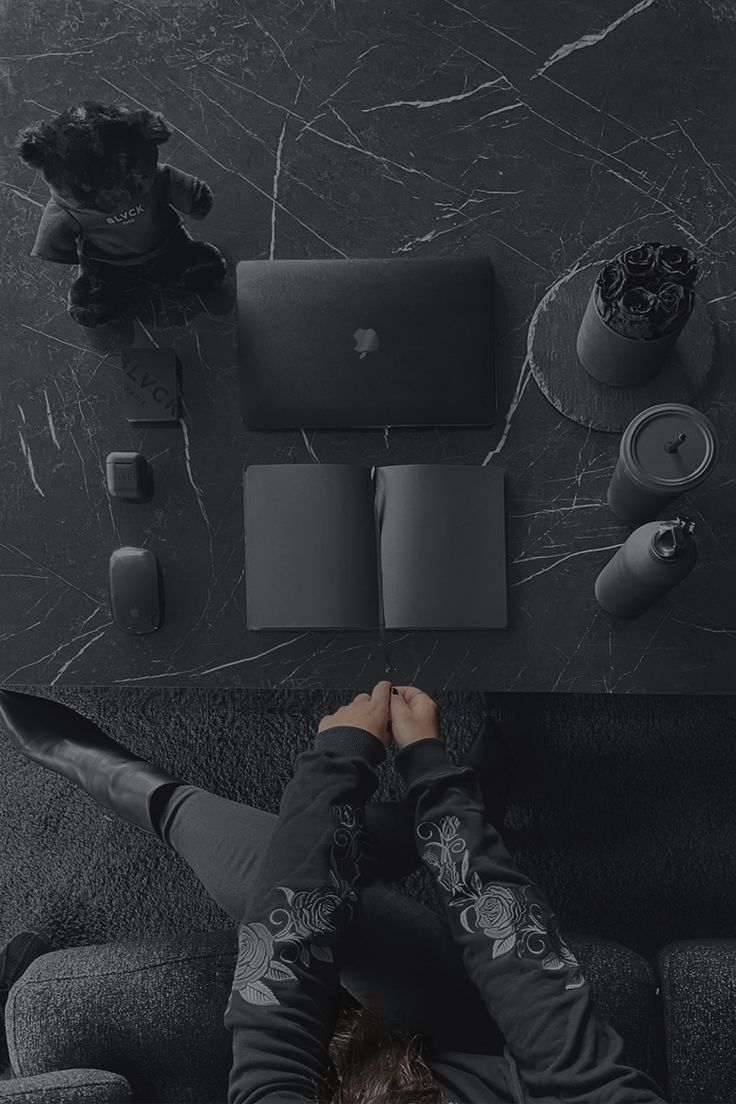 a man laying on top of a couch next to a laptop computer and other items