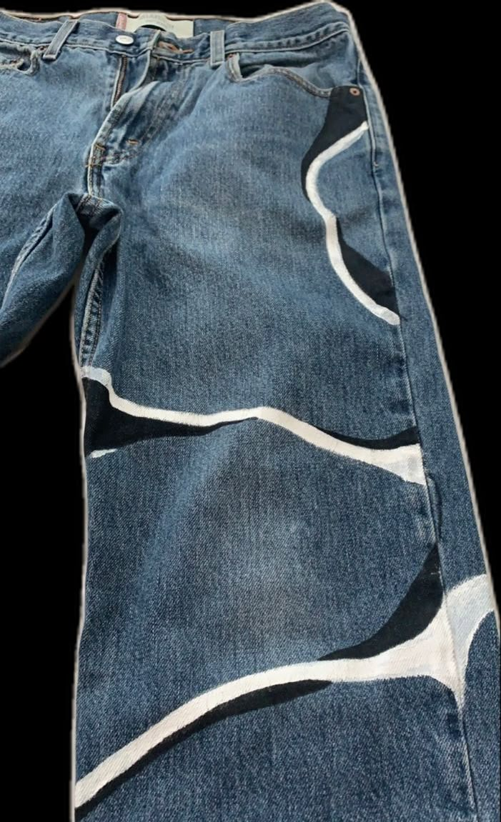 a pair of blue jeans with white and black designs on them