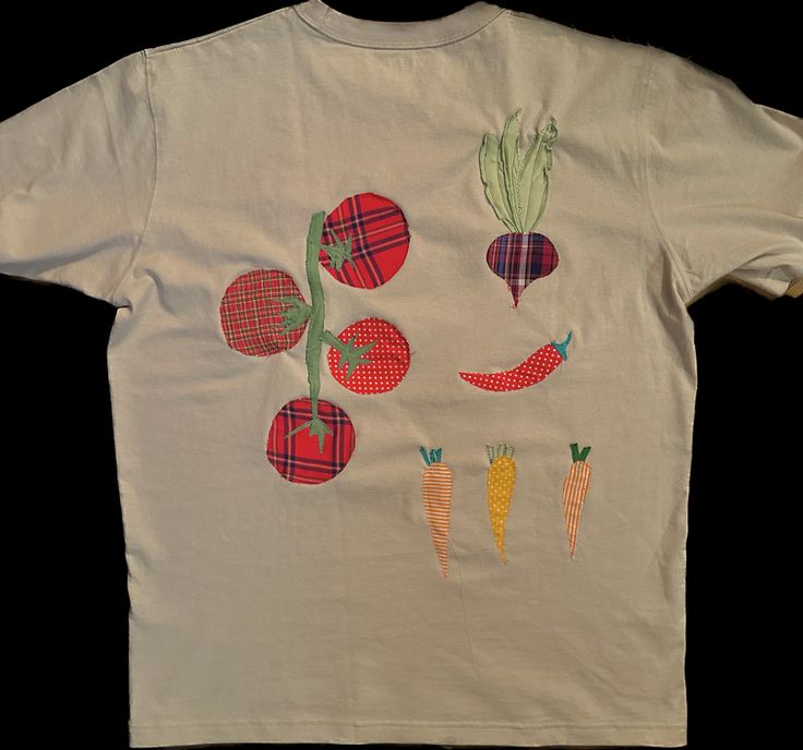 a white t - shirt with carrots and radishes drawn on it's chest