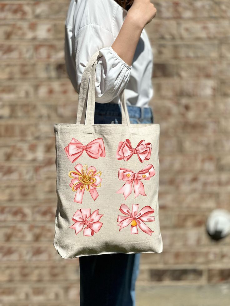 a woman holding a bag with pink bows on it