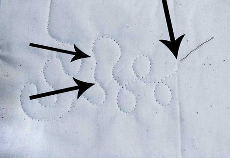 three black arrows pointing in opposite directions on a white piece of paper that has been stitched together