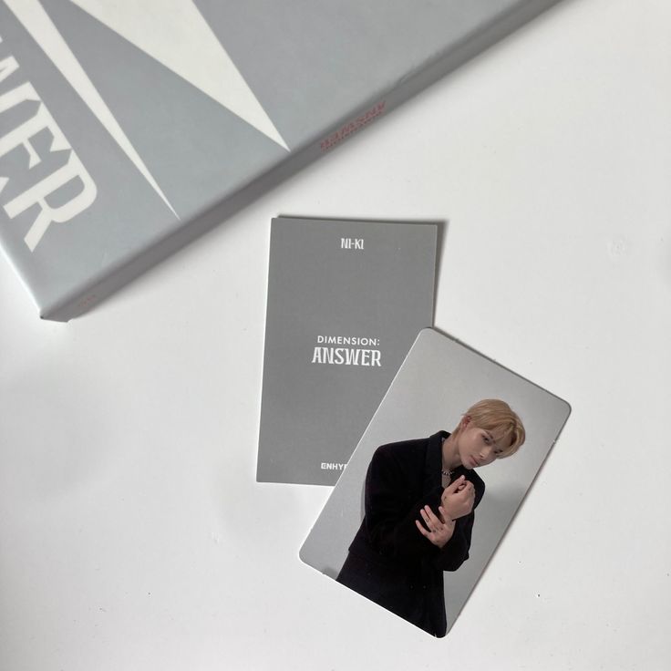 a woman is talking on her cell phone while standing in front of two book covers