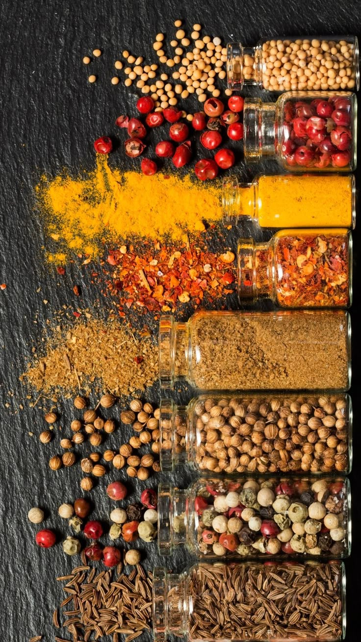 an assortment of spices and seasonings in glass containers on a black background with yellow border