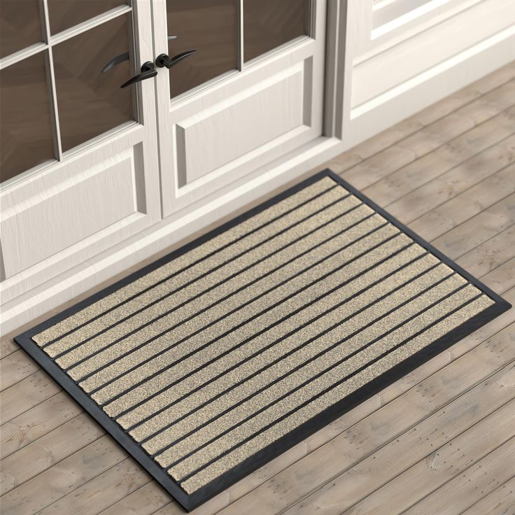 a door mat on the floor in front of two doors