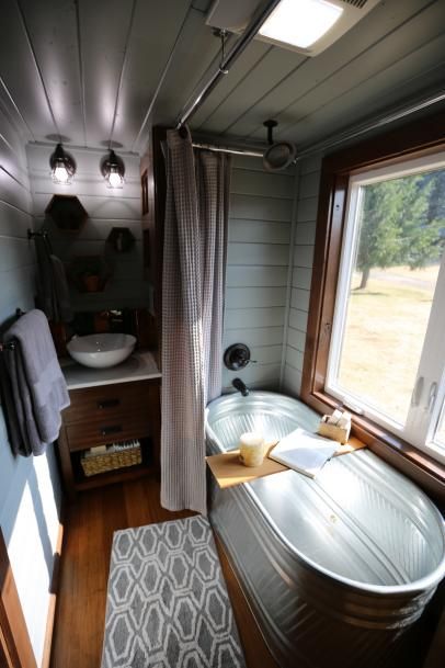 a bath tub sitting next to a window in a bathroom under a light fixture on the ceiling