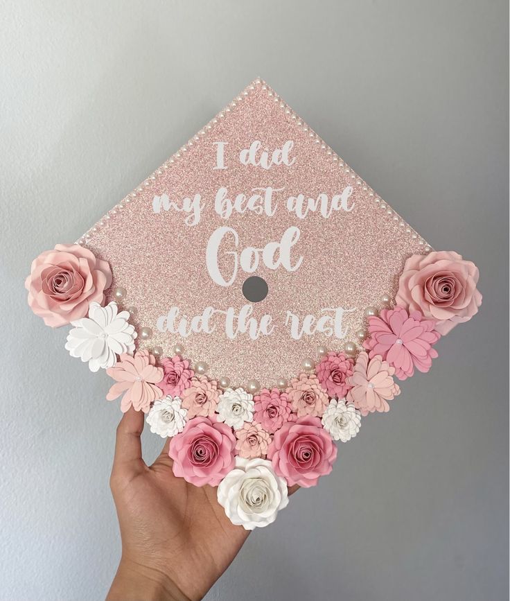 someone is holding up a pink and white graduation cap with flowers on it that says, i did my best and god at the rest