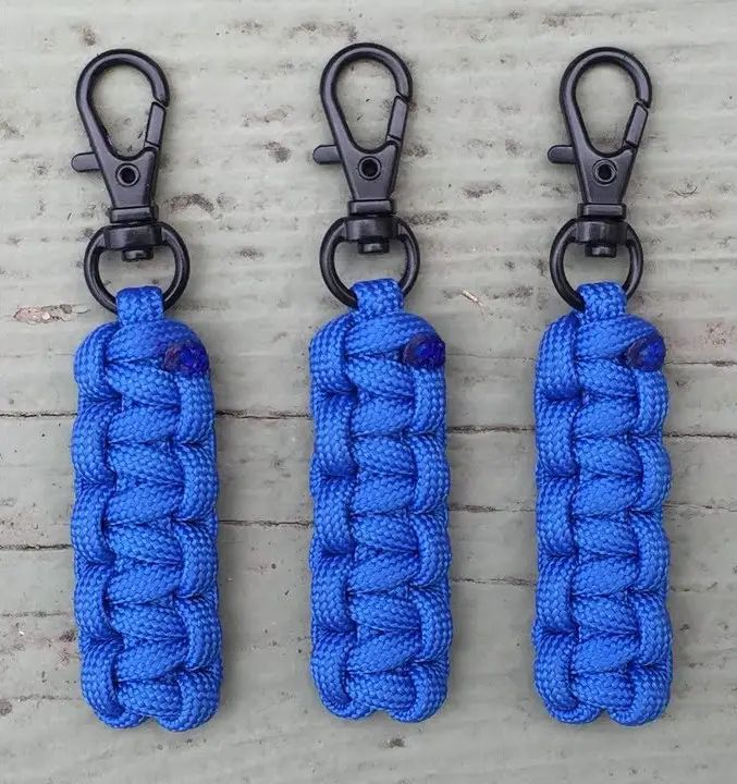 three blue paracorine key chains hanging from hooks