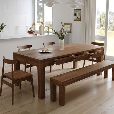 a dining room table with four chairs and a bench