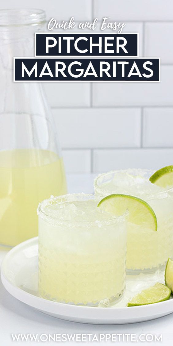 two glasses filled with lemonade and limes on a white plate next to a pitcher