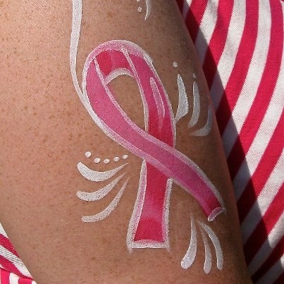 a woman's arm with a pink ribbon painted on it