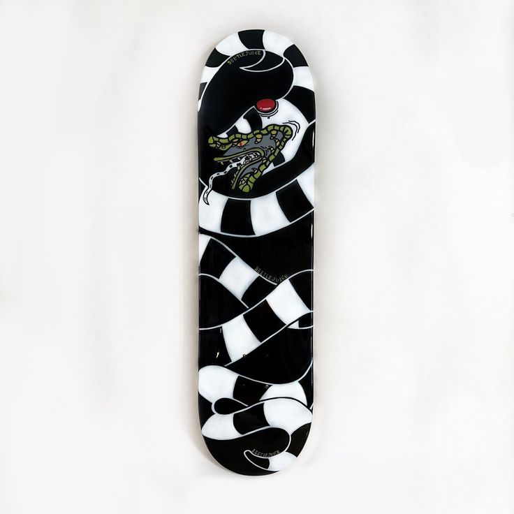 a black and white skateboard with an alligator on it's front end, against a white background