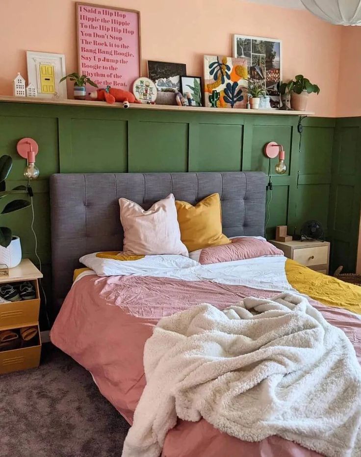 a bed with pink, yellow and green blankets on it