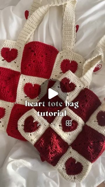 a crocheted heart tote bag sitting on top of a bed