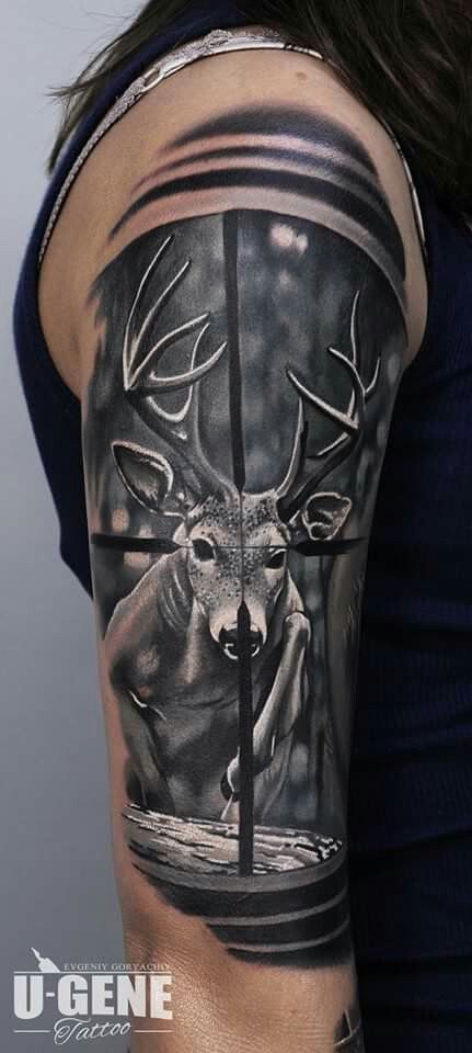 a woman's arm with a deer and cross tattoo on the back of her shoulder