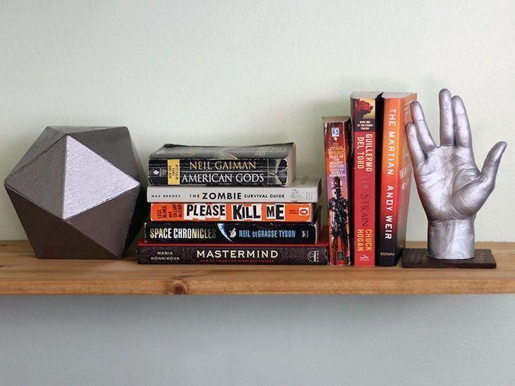 a shelf with some books and an object on it's top, along with other items