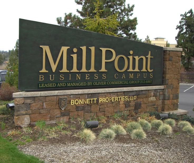 a sign for mill point business campus in front of a parking lot