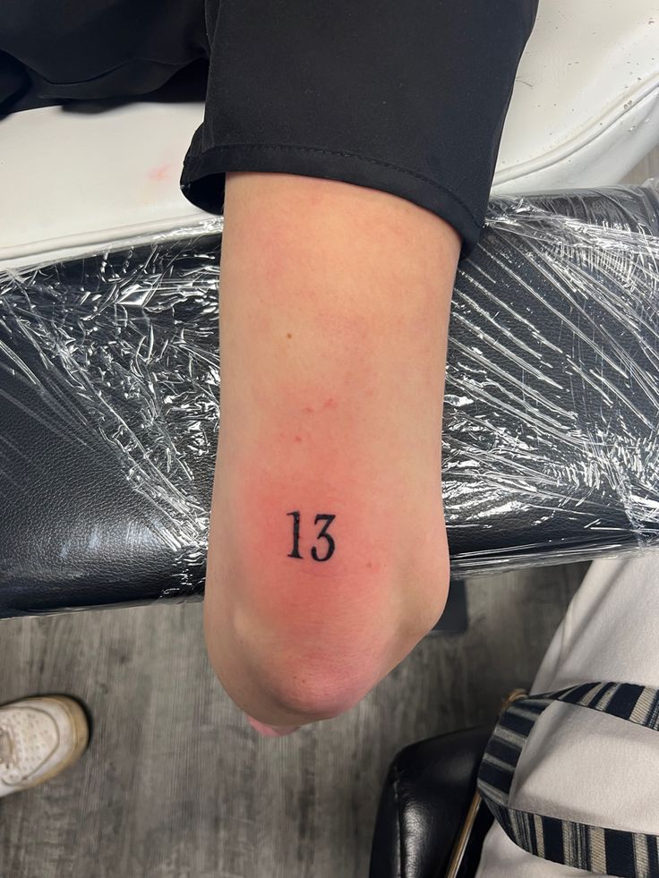 a person's foot with the number thirteen tattooed on it